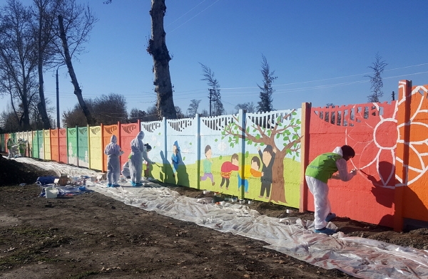 '현대엔지니어링 해피무브 고려인 빌리지 개발사업' 2차에 참가한 해피무브 글로벌 청년봉사단 22기 단원들이 아흐마드 야싸비 마을에 위치한 초등학교 담장에 벽화를 그리고 있다.