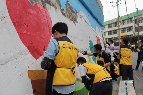 CJ대한통운 건설부문 임직원들이 동작구 남성중학교 앞에서 벽화를 그리고 있다.