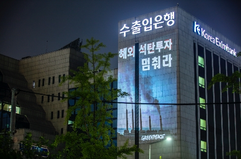 국제환경단체 그린피스 서울사무소가 6월 30일 저녁 여의도 수출입은행 건물에 레이저빔을 투사해 '해외 석탄 투자 멈춰라' 등의 메시지를 새겼다. (출처: 그린피스)