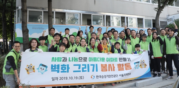 한국승강기안전공단 서울지역본부 직원들과 가족들이 19일 우면주공아파트 벽화그리기 봉사활동을 마친 뒤 기념촬영을 하고 있다.
