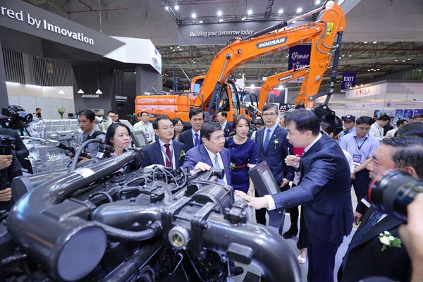 두산인프라코어 관계자가 응우옌 탄 퐁(Nguyen Thanh Phong) 호치민 인민위원회 위원장에게 GL11K 차량용 엔진 모델을 설명하고 있다.