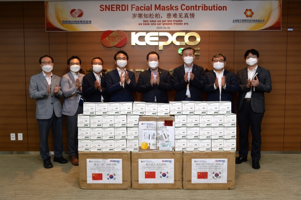 한국전력기술 이배수 사장(왼쪽 다섯번째)과 경영진이 중국 상해핵공정연구설계원으로부터 기증받은 마스크 3천장과 함께 기념촬영을 하고 있다.