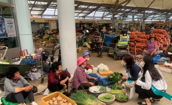 홍영아 지사장과 직원들이 전통시장에서 농산물을 구입하고 있다.