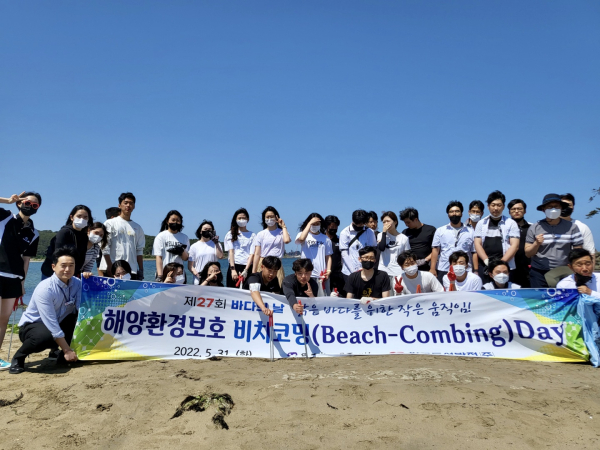 동서발전 임직원들이 울주군 진하해수욕장에서 진행한 해양환경보호 비치코밍데이에서 참석한 울산시민들과 기념사진을 촬영하고 있다.