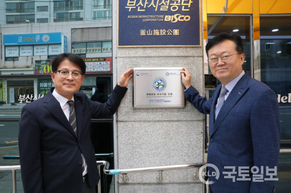 이성림 이사장(오른쪽)이 김석빈 경영본부장과 행안부 ‘재해경감 우수기업’ 인증패널 앞에서 기념촬영을 하고 있다.(사진_부산시설공단)